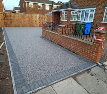 **6. Quick Installation**: Our efficient installation process minimises disruption to your daily routine, allowing you to enjoy your new Resin Bound Driveway in Wide Open in no time. With meticulous attention to detail, we ensure a flawless finish that exceeds your expectations. **7. UV Stability**: Rest assured that your Resin Bound Driveway will maintain its vibrant colour and appearance, even under prolonged exposure to sunlight. Our UV-stable resin formulations resist fading, ensuring long-lasting beauty for your home in Wide Open. **8. TrustMark Certified Craftsmanship**: As TrustMark-certified specialists, we adhere to the highest standards of quality and professionalism in every project we undertake in Wide Open, Tyne and Wear. Your satisfaction is our top priority, and we strive to exceed your expectations at every step of the process. With our focus on quality craftsmanship and customer satisfaction, we take pride in delivering exceptional results for homeowners in Wide Open and beyond. Experience the beauty and durability of Resin Bound surfaces by contacting us today. Let us bring your outdoor vision to life with our premium paving solutions.” Resin Bound Driveway New Hartley NE25