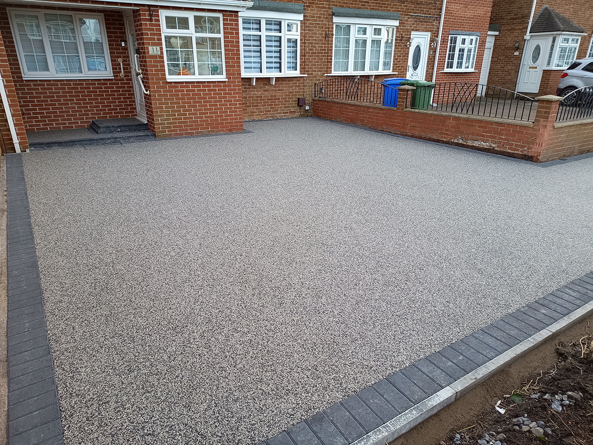 **6. Quick Installation**: Our efficient installation process minimises disruption to your daily routine, allowing you to enjoy your new Resin Bound Driveway in Wide Open in no time. With meticulous attention to detail, we ensure a flawless finish that exceeds your expectations. **7. UV Stability**: Rest assured that your Resin Bound Driveway will maintain its vibrant colour and appearance, even under prolonged exposure to sunlight. Our UV-stable resin formulations resist fading, ensuring long-lasting beauty for your home in Wide Open. **8. TrustMark Certified Craftsmanship**: As TrustMark-certified specialists, we adhere to the highest standards of quality and professionalism in every project we undertake in Wide Open, Tyne and Wear. Your satisfaction is our top priority, and we strive to exceed your expectations at every step of the process. With our focus on quality craftsmanship and customer satisfaction, we take pride in delivering exceptional results for homeowners in Wide Open and beyond. Experience the beauty and durability of Resin Bound surfaces by contacting us today. Let us bring your outdoor vision to life with our premium paving solutions.” Resin Bound Driveway New Hartley NE25